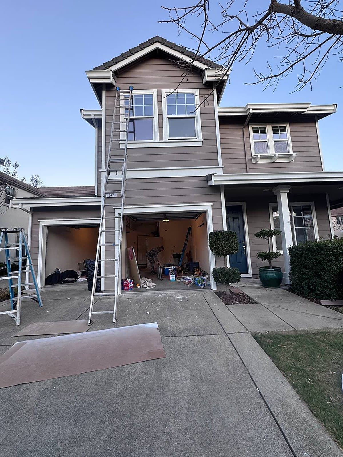 Two-story home during exterior repaint
