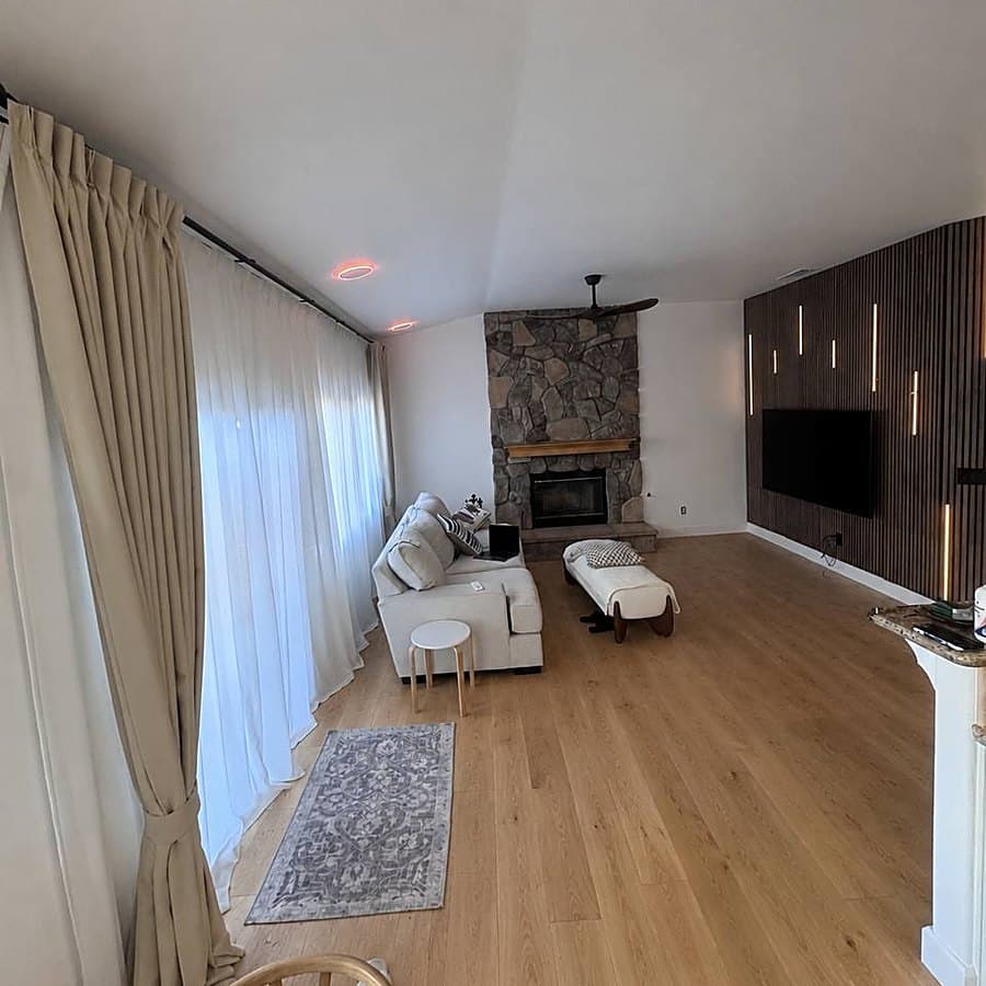 Freshly painted living room with plank floors and a lit slat feature wall