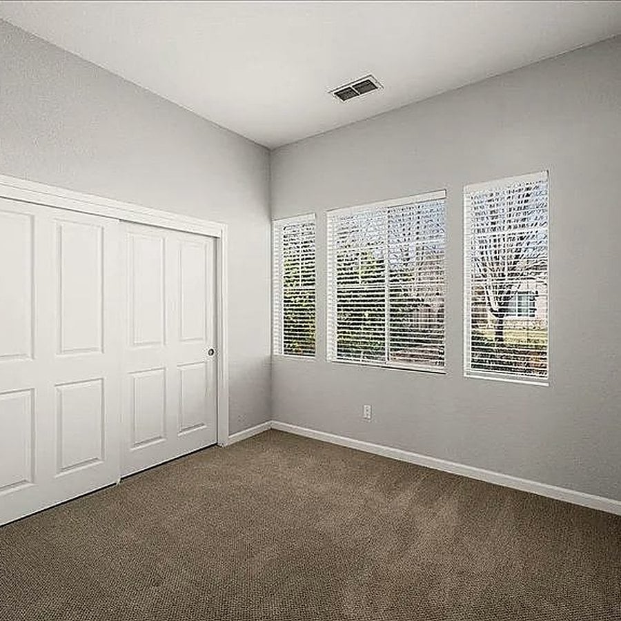 Before: bedroom with beige carpet and sliding closet doors