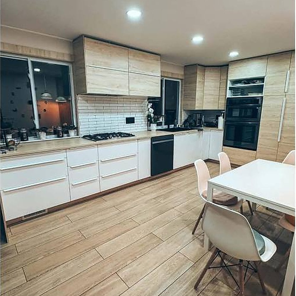 Remodeled kitchen with light wood cabinetry and white countertops
